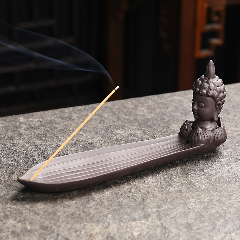Buddha head incense stick holder on elongated leaf-shaped ash catcher