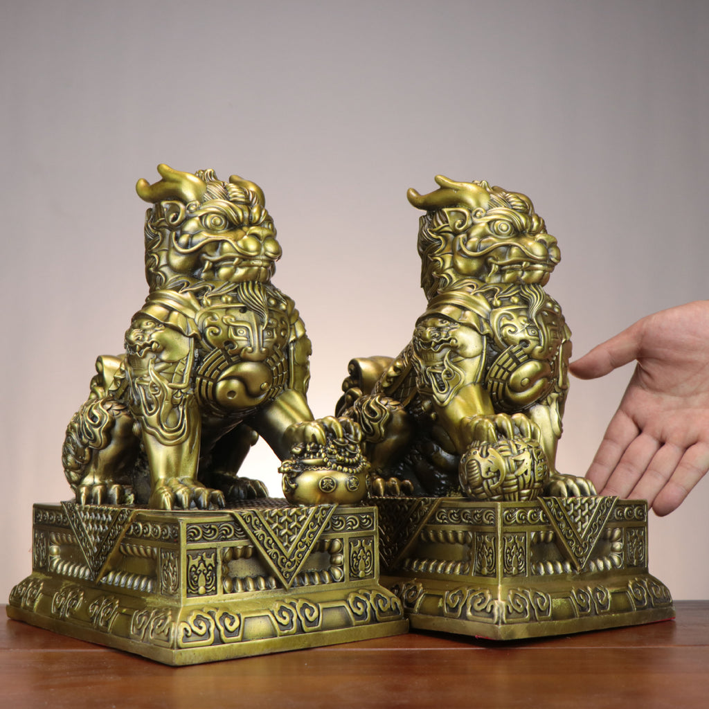 Chinese Caifu General Qilin copperware pair with Bagua chest medallions, treasure bag and ingot details on ornate bases