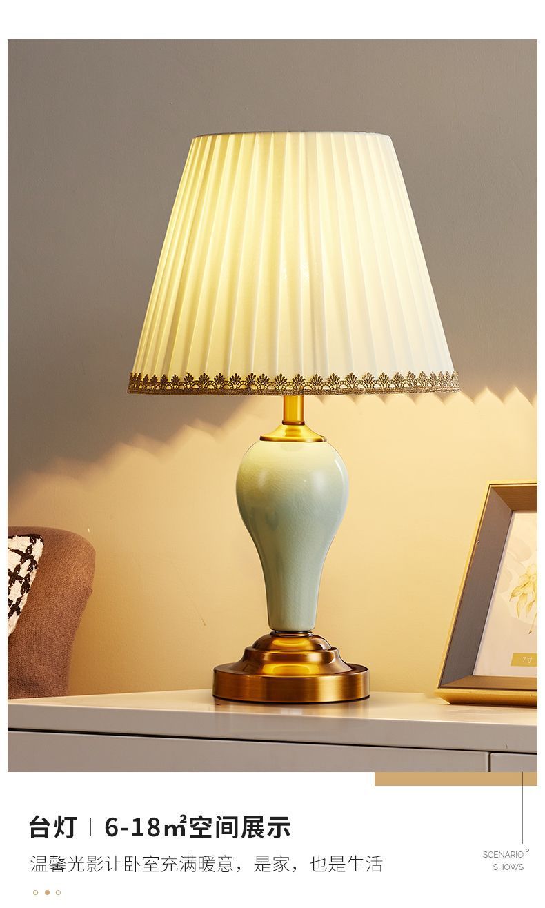 Celadon ceramic lamp glowing on side table with cream pleated shade