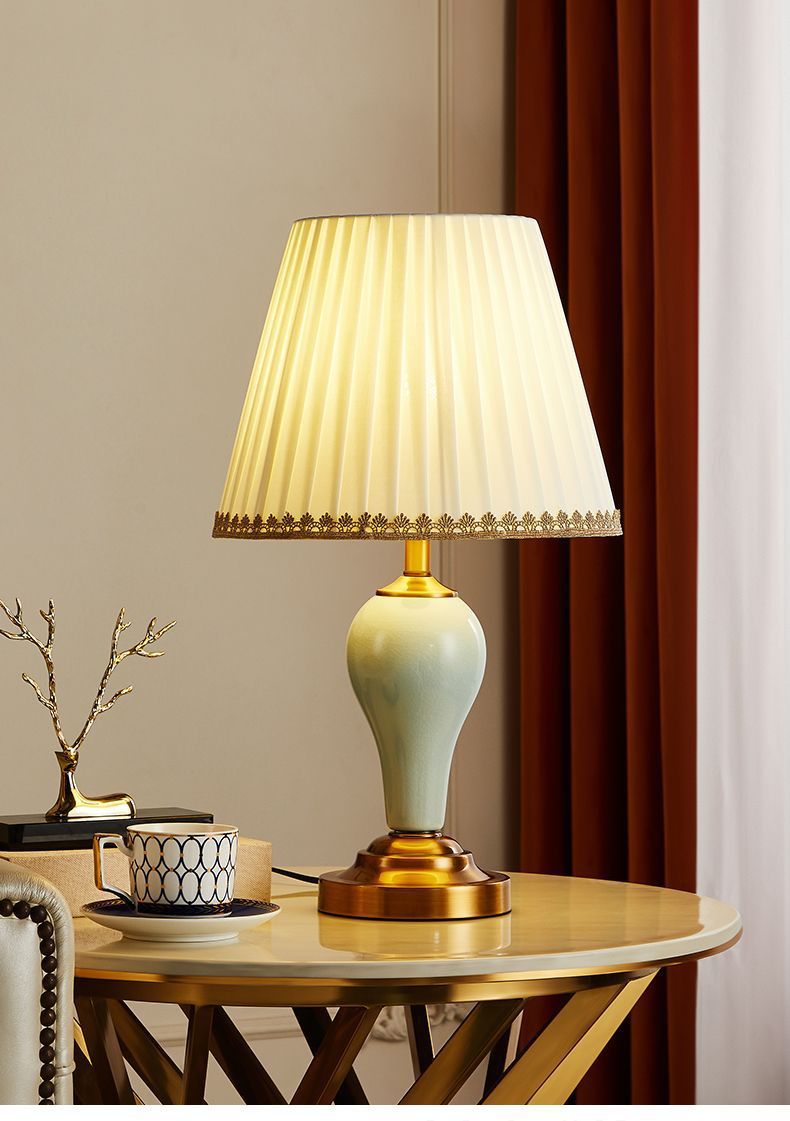 Celadon ceramic table lamp with antique brass-tone base on round side table