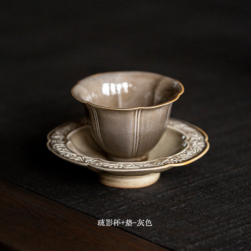 Flower form celadon tea cup and ornate saucer