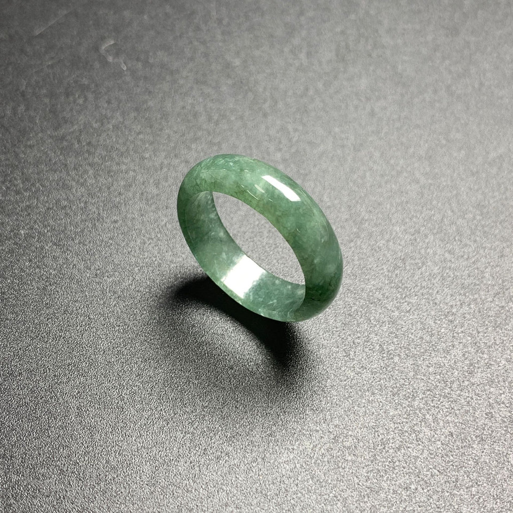 Polished green jadeite stone band ring with natural mottled translucency