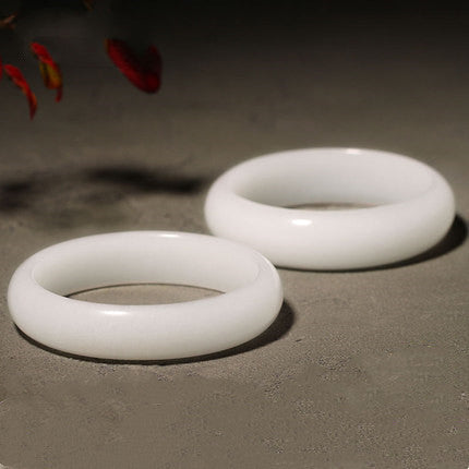 Certified white jade bangle showing creamy stone surface and curved edges