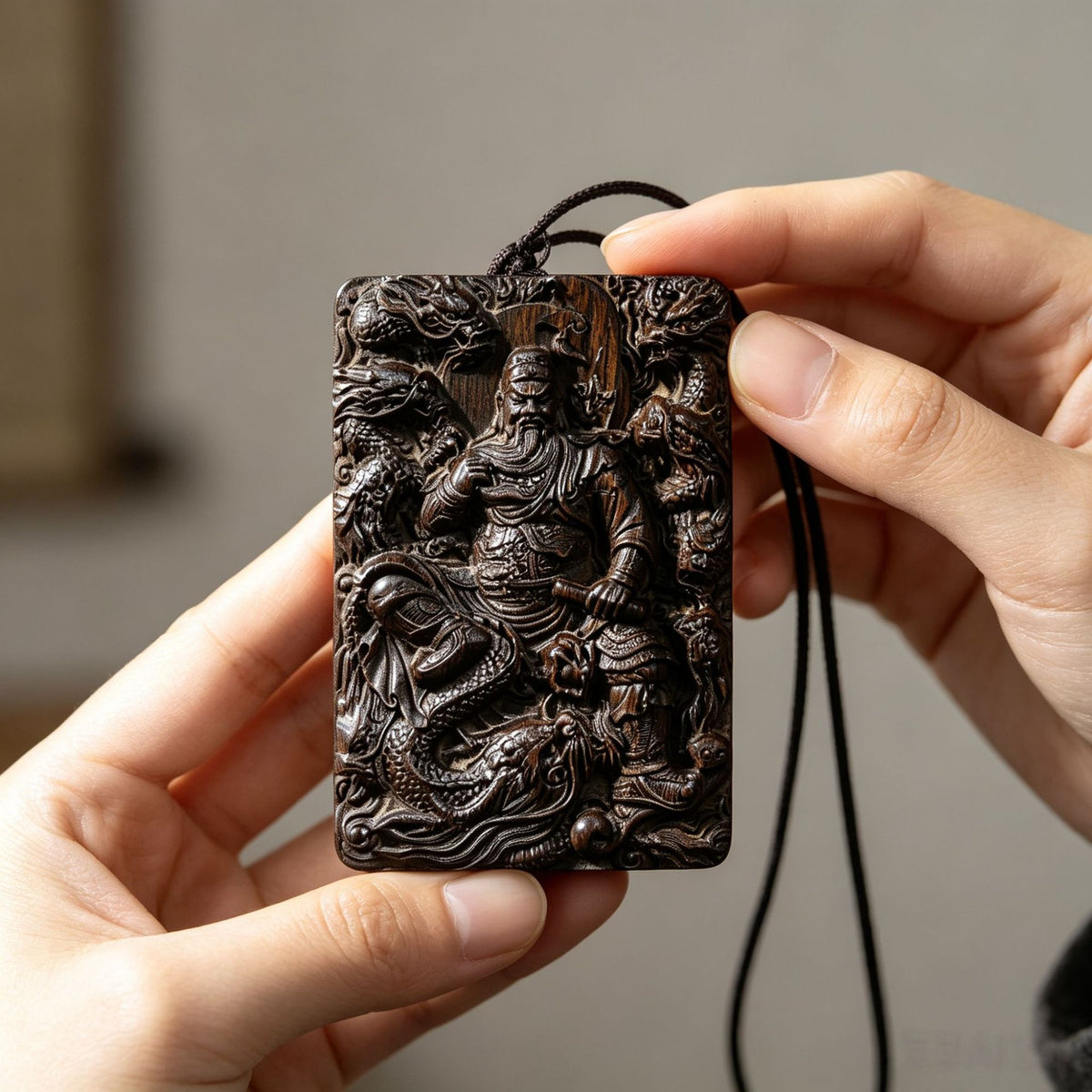 Dark carved wood Guan Yu or Guan Gong pendant with dragon relief and detailed Chinese spiritual carving