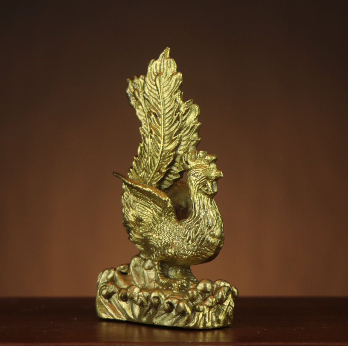 Front three-quarter view of Chinese Fenghuang phoenix copperware ornament with feather relief and wave base, auspicious cultural home and office decor