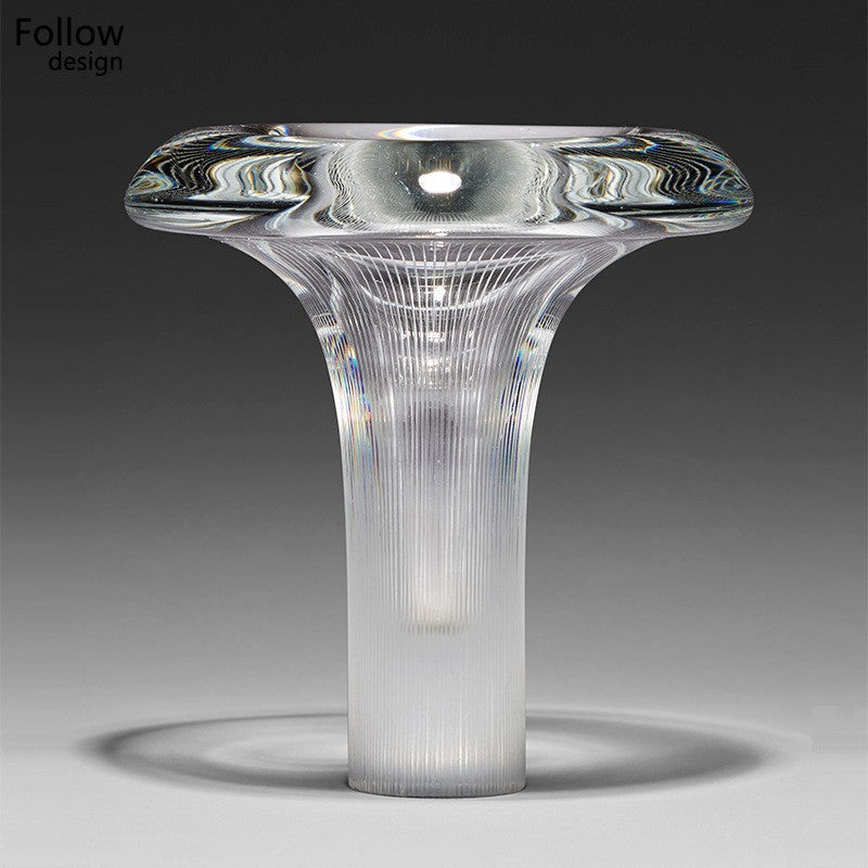 Clear sculptural glass mushroom table lamp on side table