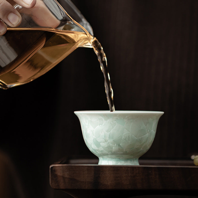 Tea being poured into celadon green crystalline glaze ceramic Gongfu cup