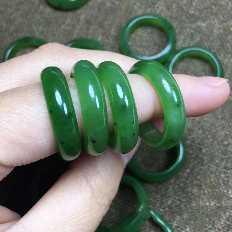 Deep green polished stone thumb ring shown on fingers