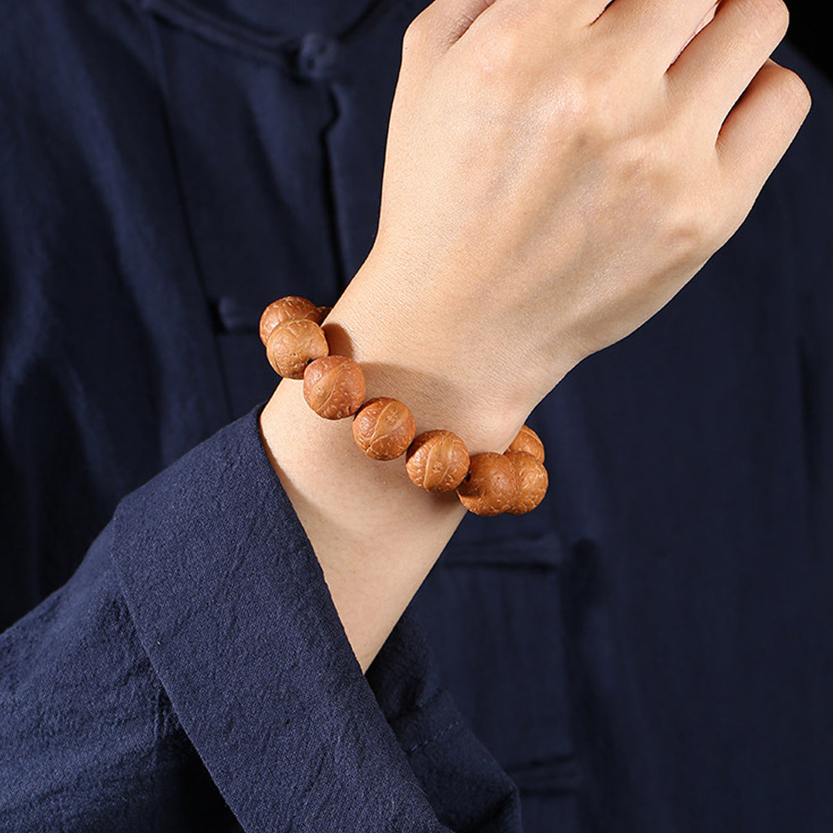 Fengyan Bodhi 14mm bracelet worn on wrist with dark Neo-Chinese clothing