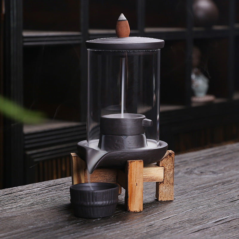 Tall glass chamber backflow incense burner with purple clay basin and wood support
