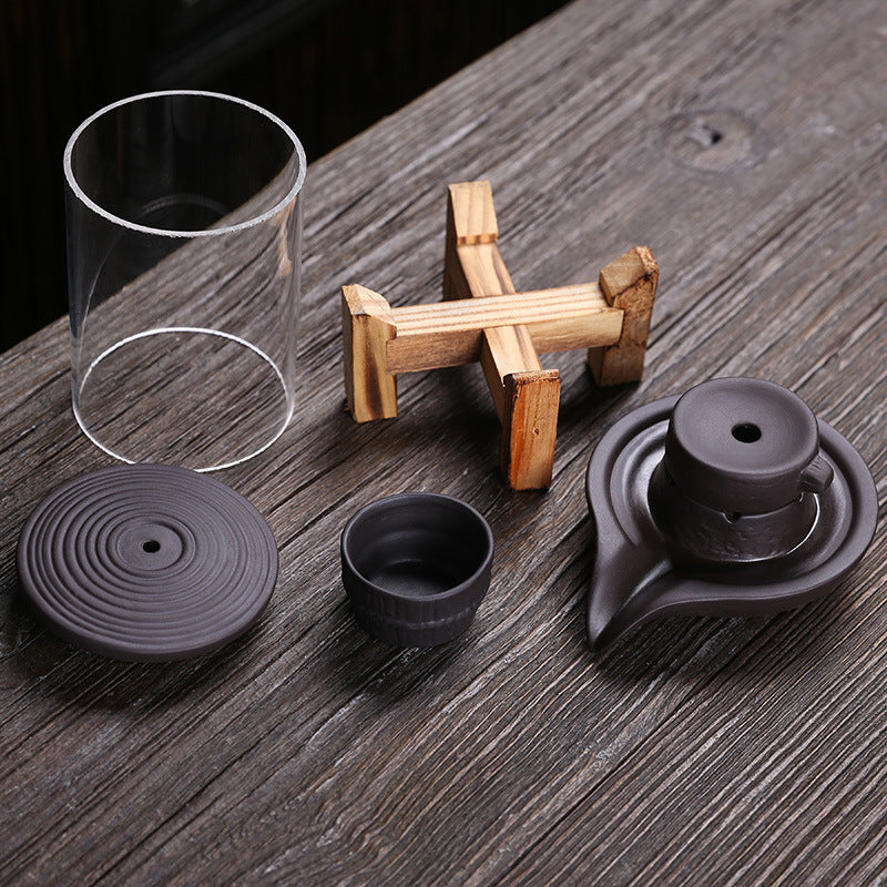 Disassembled glass purple clay backflow incense burner components and natural wood stand