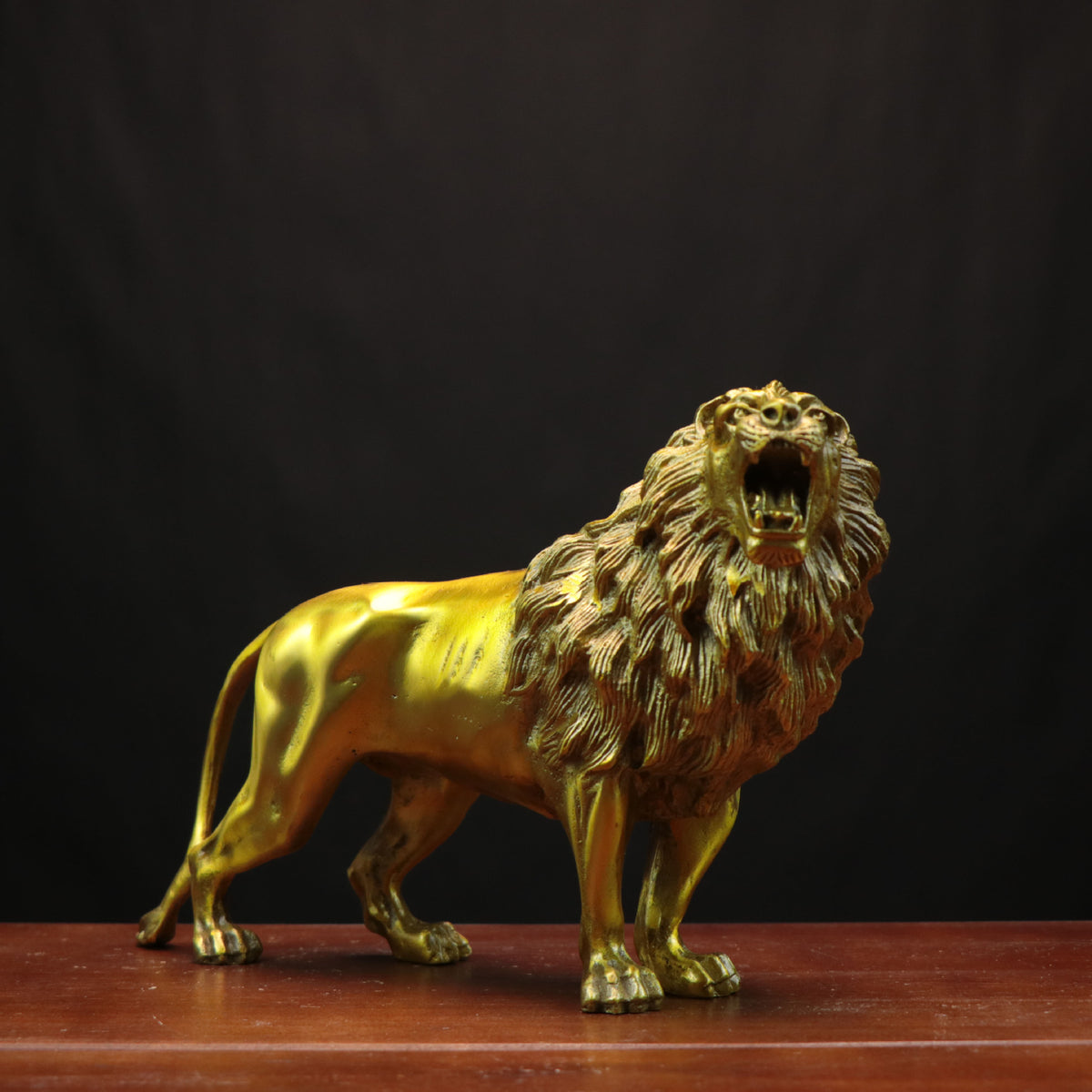 Golden copper lion sculpture front angle with open mouth and detailed mane