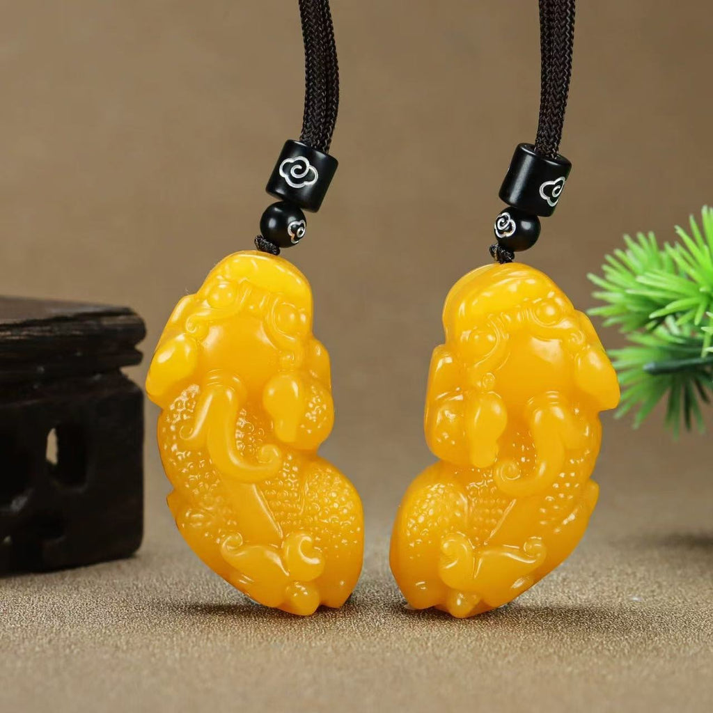 Pair of golden yellow Pixiu pendants displayed upright