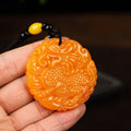 Golden yellow round Qilin pendant held in hand