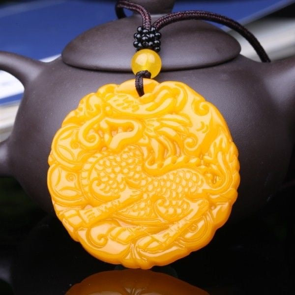 Chinese Qilin carved round pendant displayed against teapot