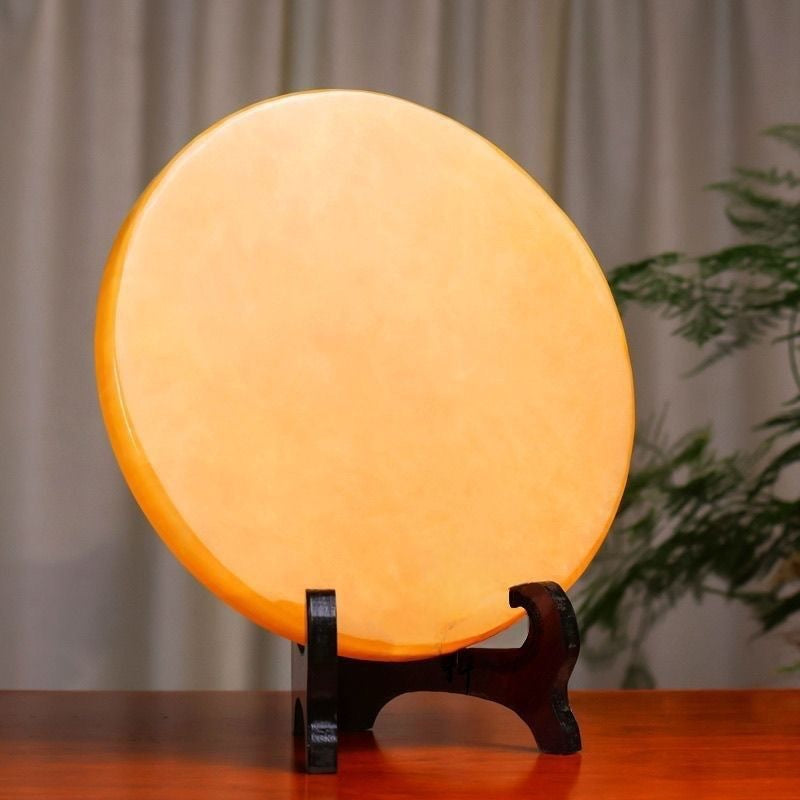 Side view of yellow bi-disc ornament showing slim profile on wood stand