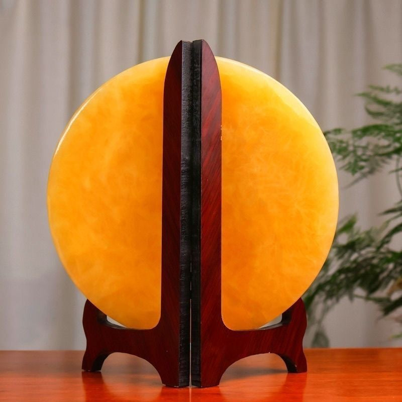 Rear view of yellow circular display ornament with dark wood stand