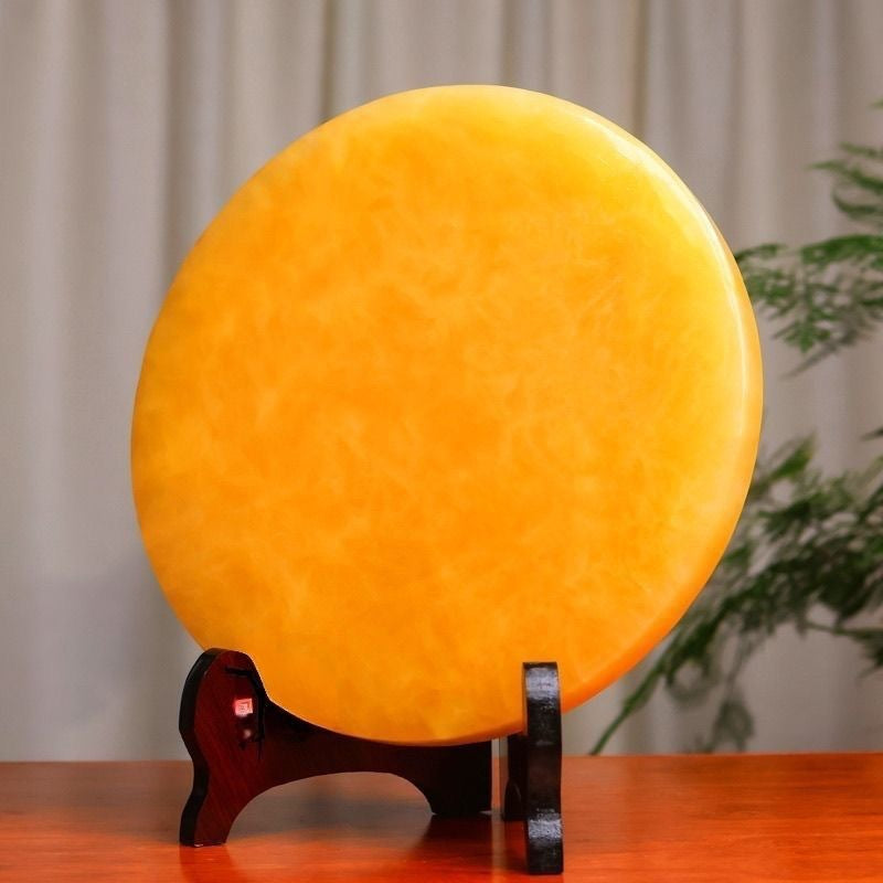 Angled view of golden yellow peace disc ornament for console table decor