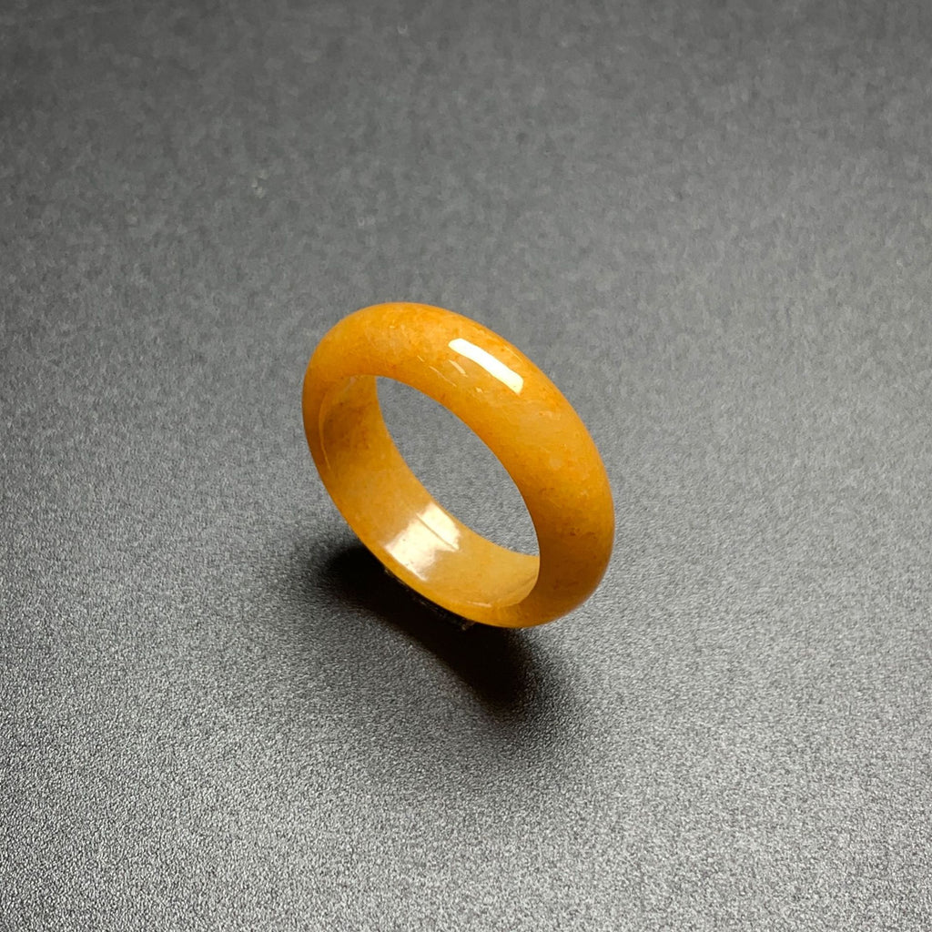 Honey yellow jadeite ring on dark background highlighting smooth stone luster