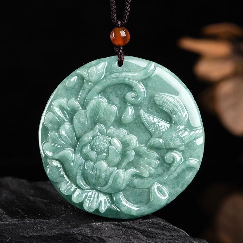 Green Chinese auspicious bird and flower pendant displayed on dark background