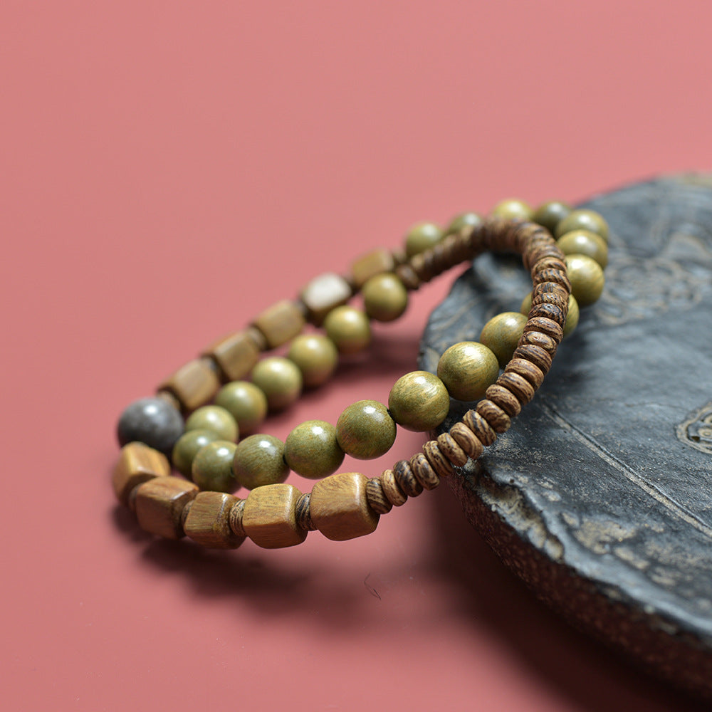 Green sandalwood-style double-layer wood bead bracelet displayed with book and red background for tea room and study styling