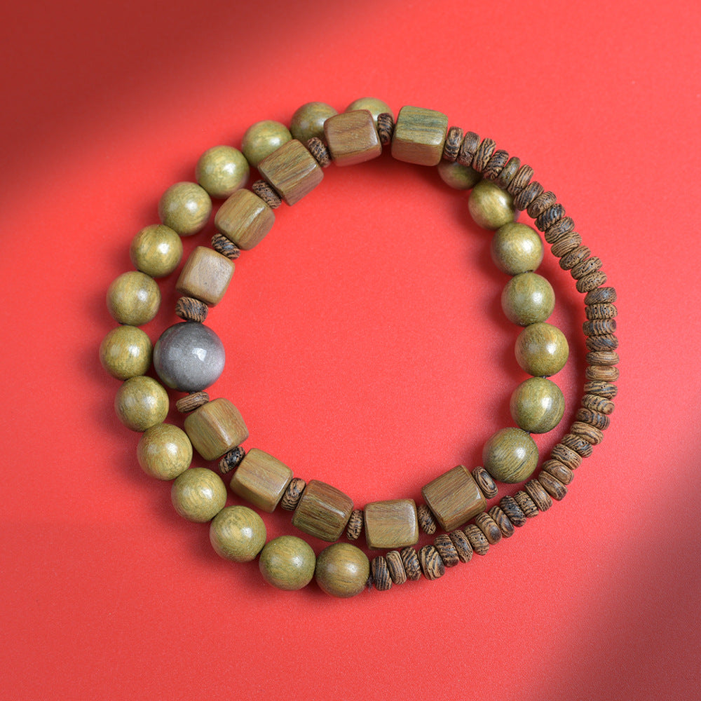 Top view of green sandalwood-style double-layer bracelet showing 8mm round beads, 7mm cube beads, 5mm disc beads and gray focal bead