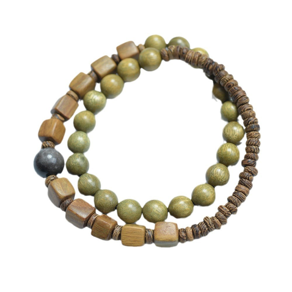 Green sandalwood-style double-layer bracelet on white background with olive round beads, cube wood beads, disc beads and gray focal bead