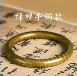 Green sandalwood-style round wood bangle displayed on Chinese calligraphy paper