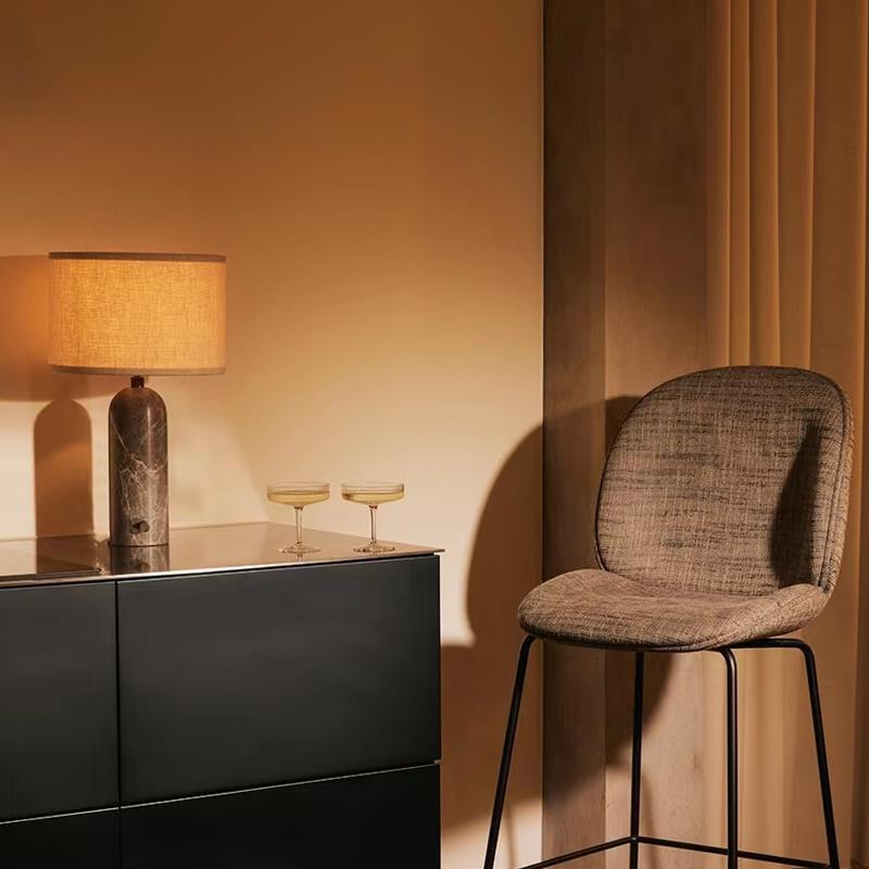 Grey marble capsule table lamp glowing on modern sideboard