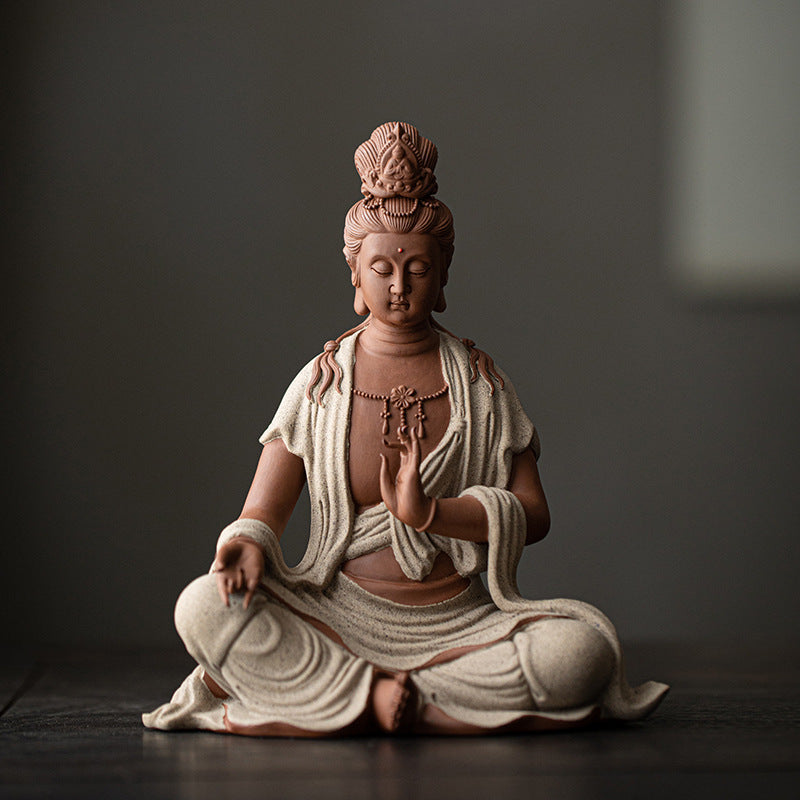 Seated Guanyin ceramic sculpture in warm terracotta and ivory robe