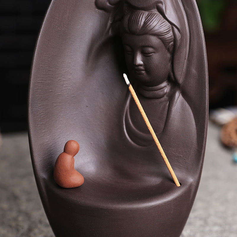 Guanyin leaf purple clay incense burner shown with incense stick and monk figure