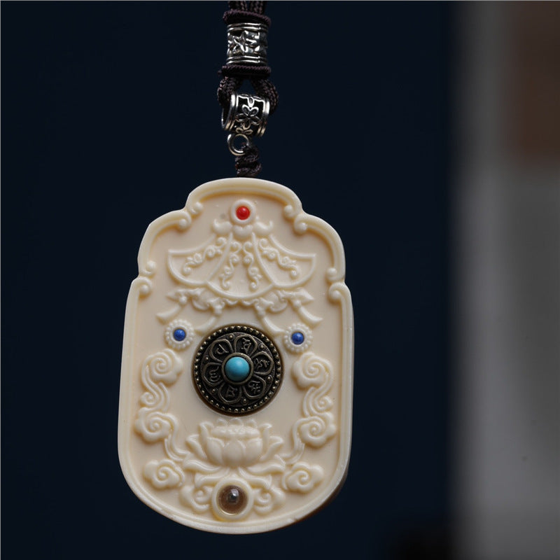Back view of ivory-tone Guanyin pendant with lotus, cloud motifs and central decorative medallion