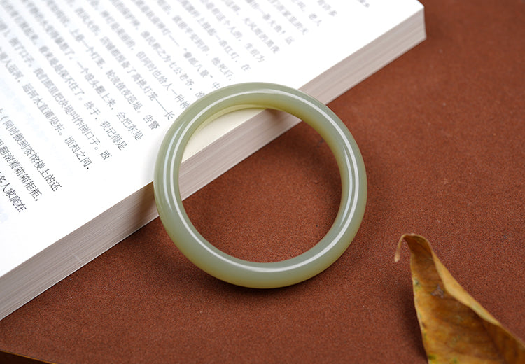 Natural Hetian jade bangle showing soft celadon green translucency