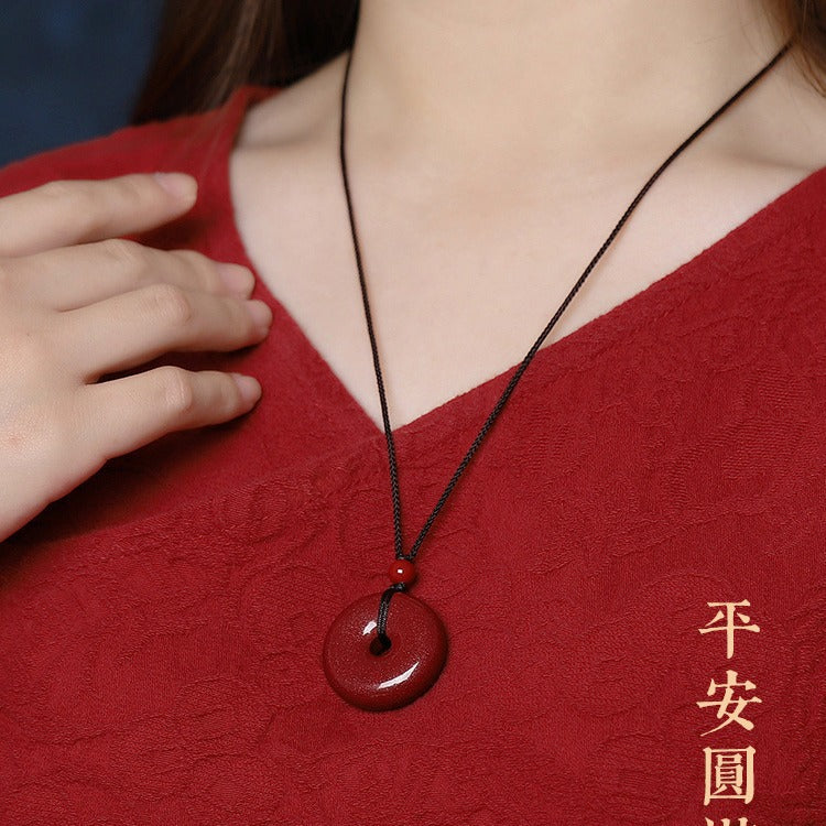 Red cinnabar Ping An Kou necklace styled on red background