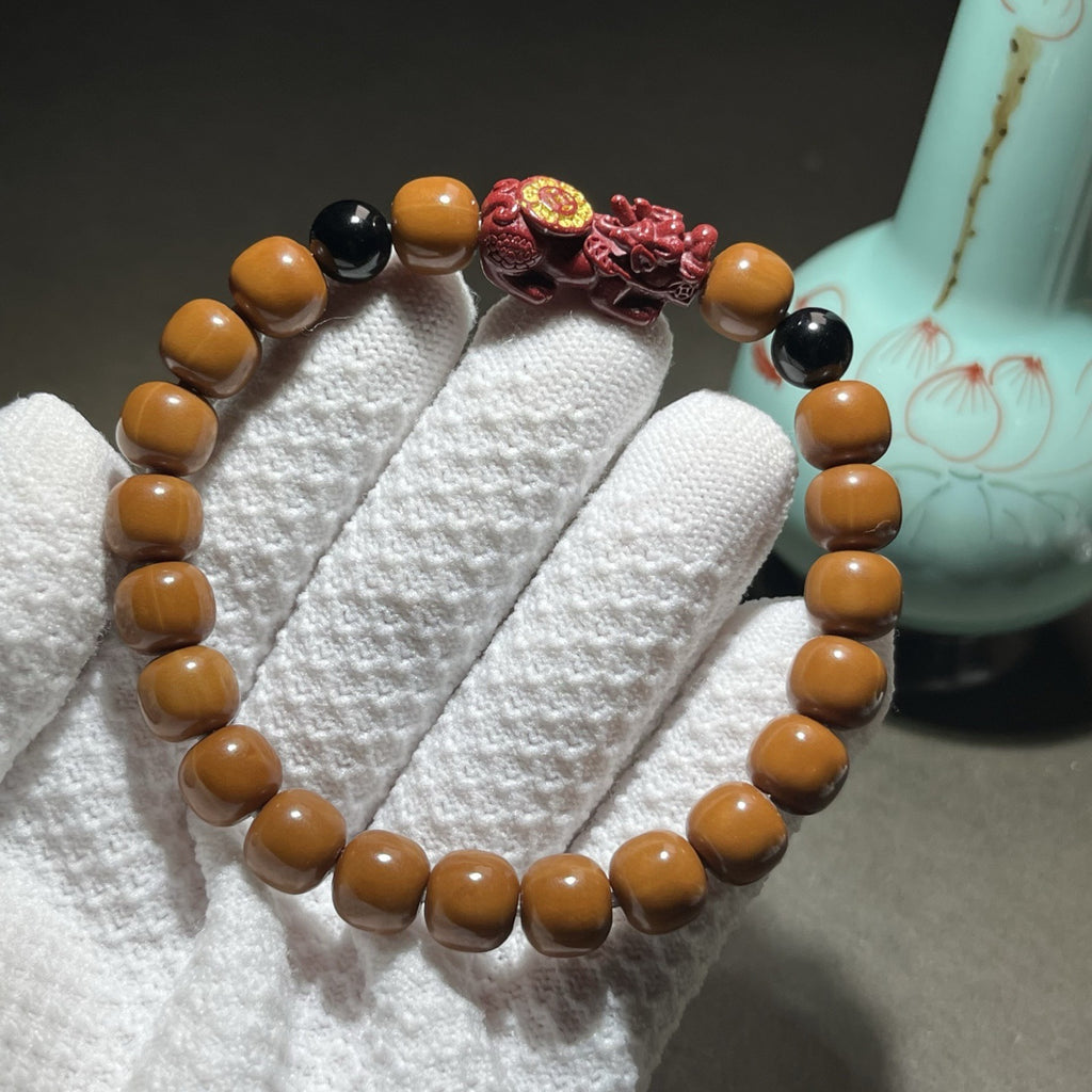 Houtou wenwan 8x9mm barrel bead bracelet with red cinnabar-tone Pixiu focal and black accent beads