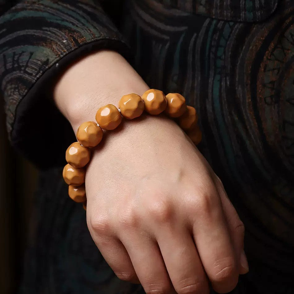 Houtou Wuxiang Bodhi bracelet worn on wrist showing warm caramel high-polish faceted beads