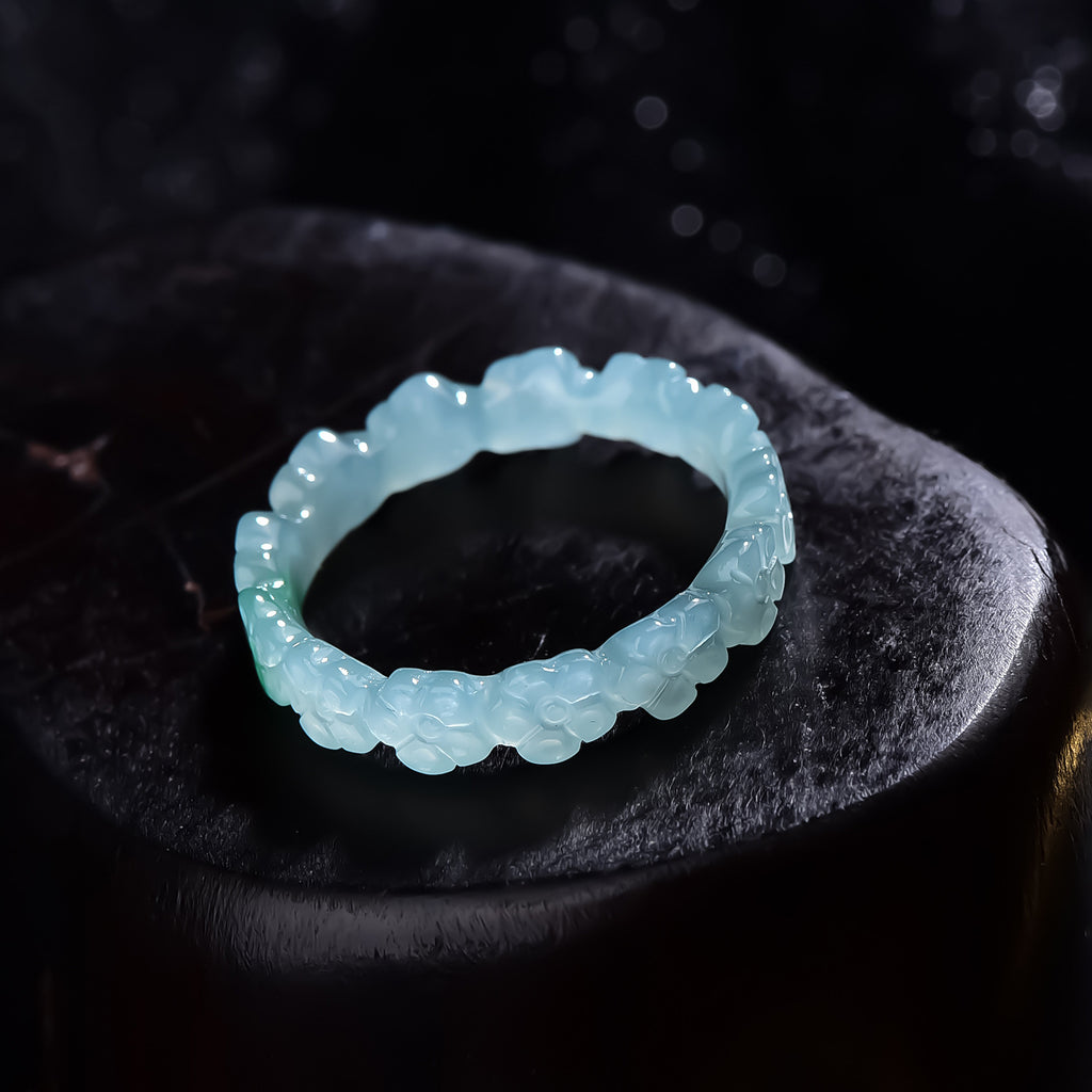 Carved jadeite floral ring showing continuous blossom relief