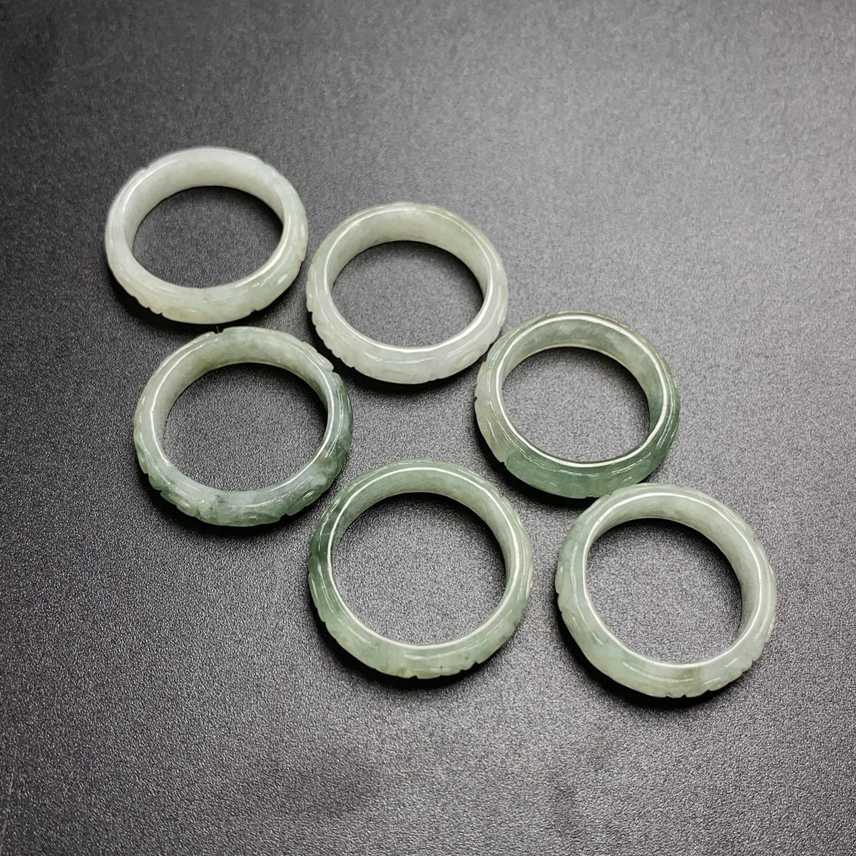 Icy pale green jadeite carved key fret rings showing traditional meander edge pattern