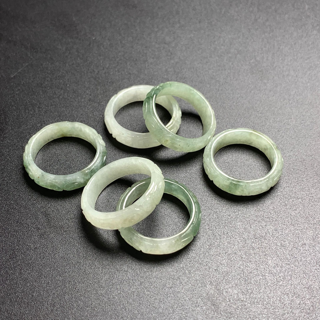 Group of pale green carved jadeite rings with geometric key fret detailing