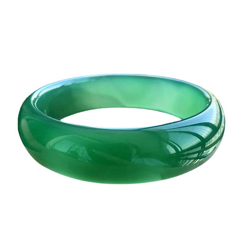 Deep emerald green chalcedony wide solid stone bangle on white background