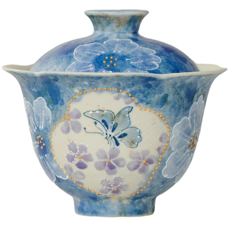 Close-up of hand-painted butterfly and floral motif on ink-blue ceramic gaiwan