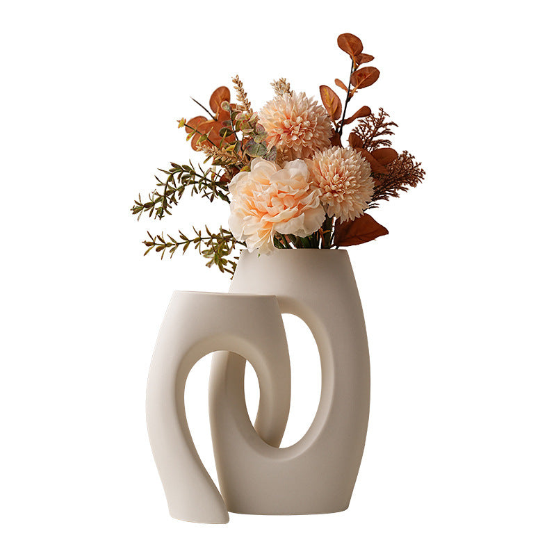 Modern abstract white ceramic loop vase styled with flowers