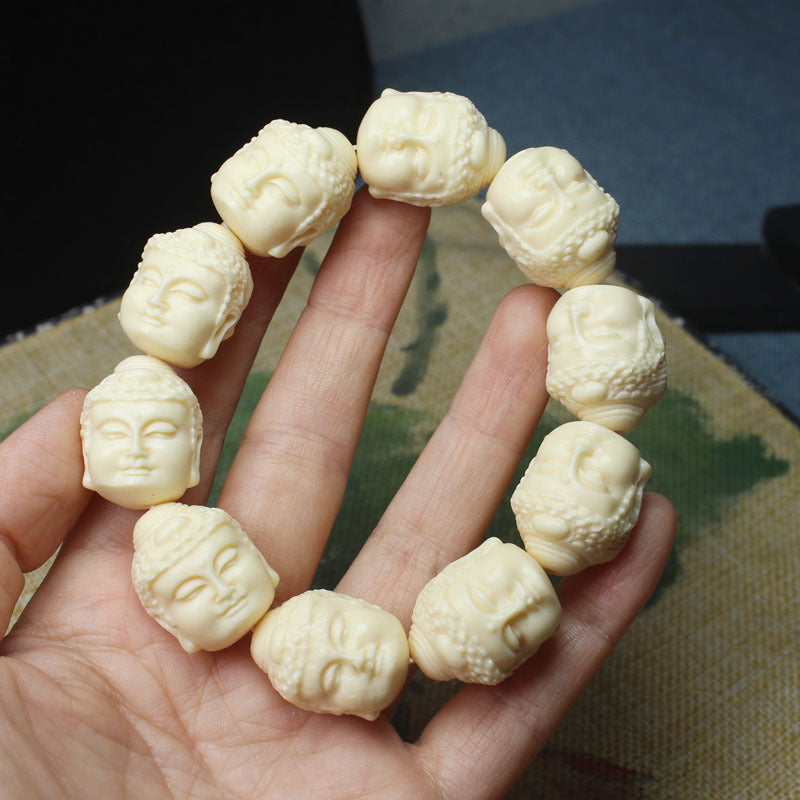 Ivory nut Buddha head carved bead bracelet in creamy botanical ivory tone, approximately 20mm beads