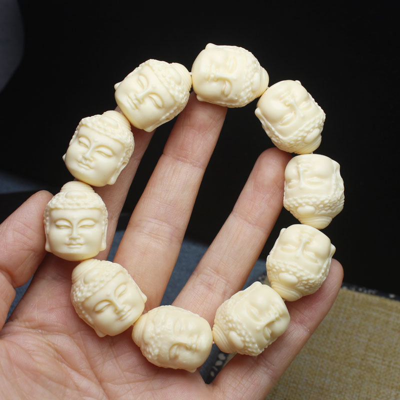 Ivory nut Buddha head carved bead bracelet shown in hand with multiple serene face carvings