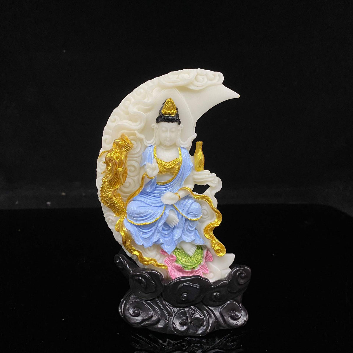 Front view of ivory nut crescent moon Guanyin statue with gold dragon, blue robes and black cloud base