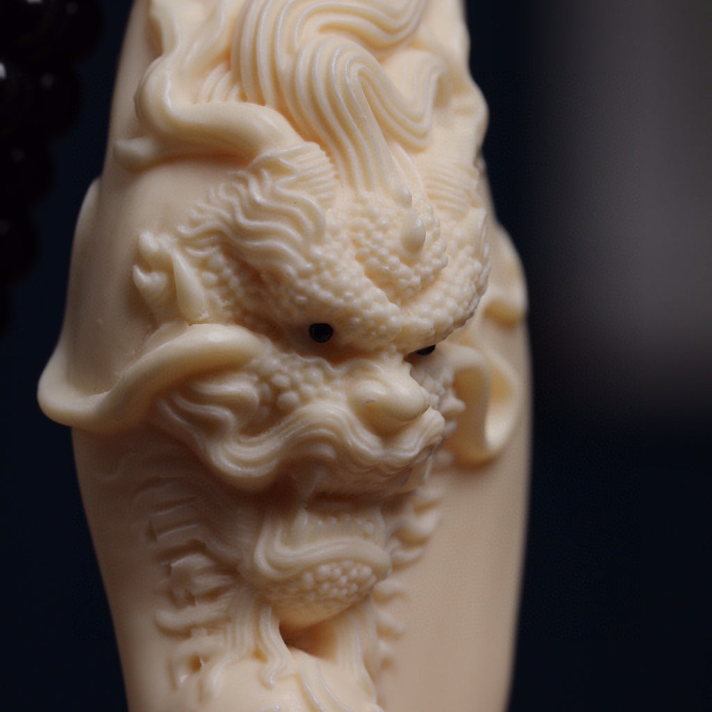 Close-up of ivory nut Chinese dragon relief carving with detailed scales, mane and facial features