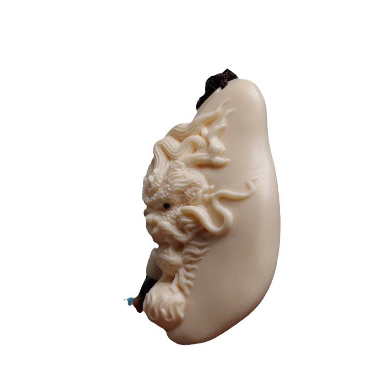 Side view of ivory nut Chinese dragon relief pendant showing sculptural depth and curved profile