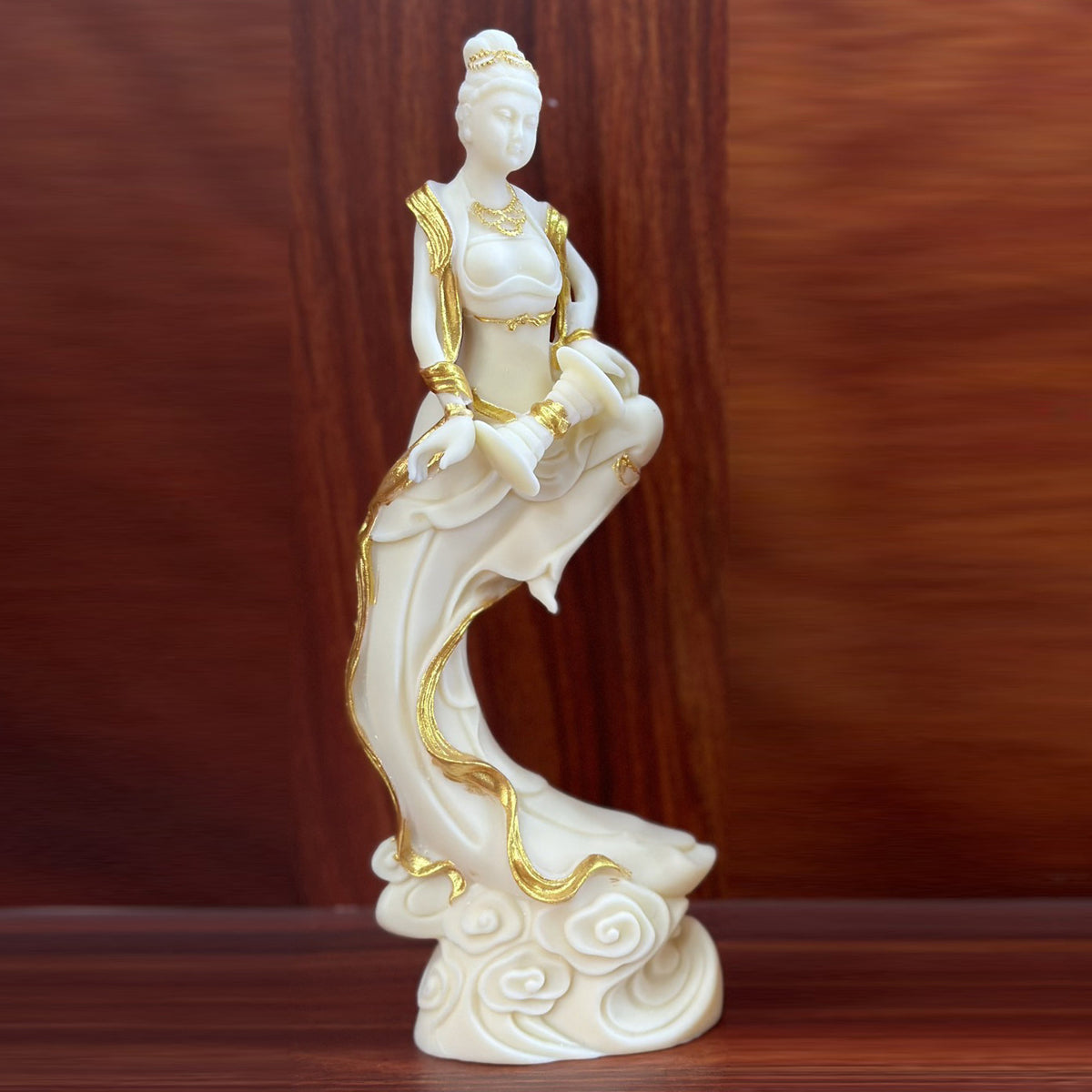 Ivory nut Dunhuang apsara with drum and gold-tone accents on flowing robes and cloud base