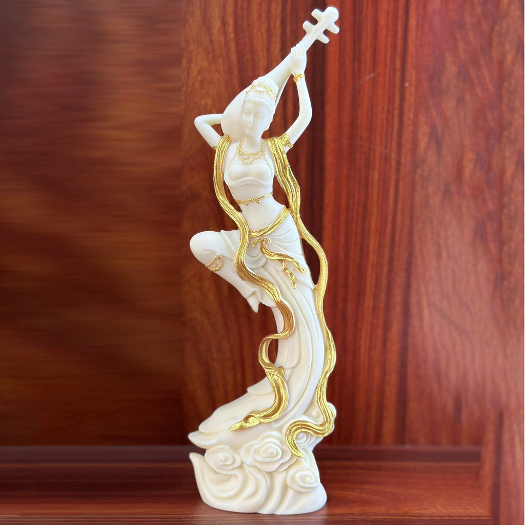Ivory nut Dunhuang flying apsara with pipa and gold-tone accents on flowing ribbons and cloud base