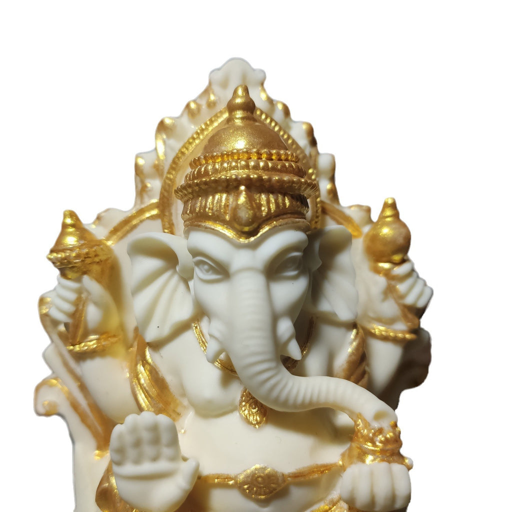 Close-up of gold-accent ivory nut Ganesha statue showing crown, face and sculpted hand details